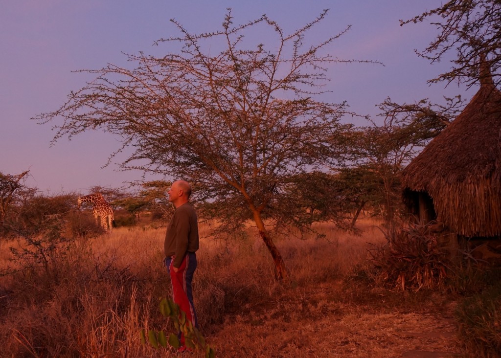John, back on Lewa, watching the sun rise this morning with a tall, quiet visitor.